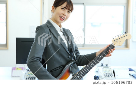 職場でエレキギターを演奏する女性会社員イメージ 職場でエレキギターを演奏する女性会社員イメージ 106196782