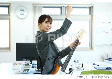 職場でエレキギターを演奏する女性会社員イメージ 106196785