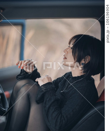 車に乗った女性が膝を立てて座ってる 車に乗った女性が膝を立てて座ってる 106196904