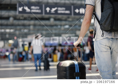 Hand of man holding suitcase at airport. 106197166