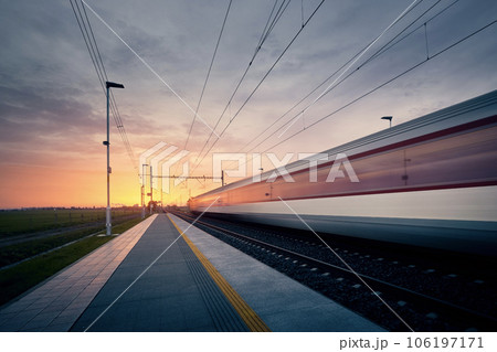 Long exposure of train on railroad track at sunrise. 106197171