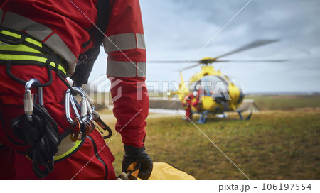 Safety harness of paramedic of emergency service in front of helicopter Safety harness of paramedic of emergency service in front of helicopter 106197554