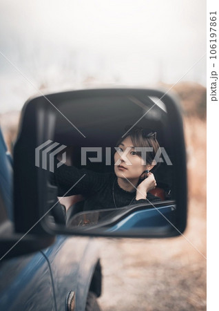 車のバックミラー越しの運転席の女性 車のバックミラー越しの運転席の女性 106197861