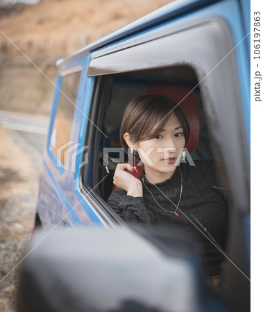 バックミラーで自分を見てる運転席の女性 106197863