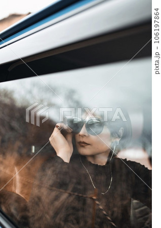 車の窓越しに見る運転席の女性 106197864