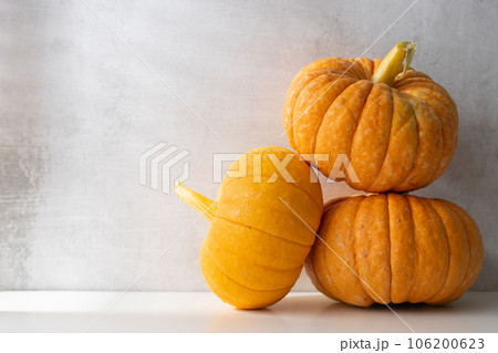 three whole ripe pumpkins on a light background. Autumn harvest 106200623