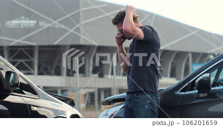 Car accident with wrecked car and man on phone. Man calling to report car accident. Road safety and insurance concept. Car accident with wrecked car and man on phone. Man calling to report car accident. Road safety and insurance concept. 106201659