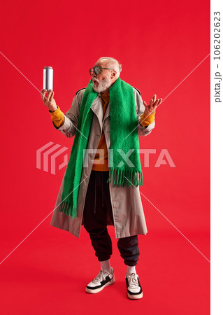 full-length portrait of funny aged man with surprised emotion on his face dressed trendy, stylishly holding can in his hands. full-length portrait of funny aged man with surprised emotion on his face dressed trendy, stylishly holding can in his hands. 106202623