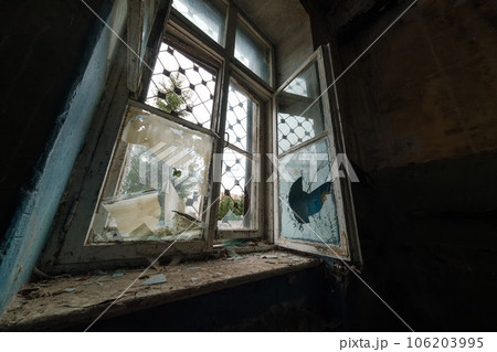 Low angle of dirty broken old fashioned window with shabby windowsill of damaged building Low angle of dirty broken old fashioned window with shabby windowsill of damaged building 106203995