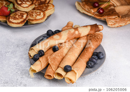 Variety of pancakes with berries, honey and jam. Different kind of pancakes. Traditional and tiny, crepe and old fashioned pancakes. Festive brunch set. 106205006
