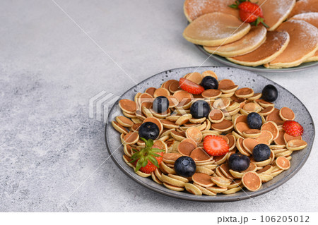 Tiny pancake cereal With Strawberries And Blueberries for breakfast. Food Background. 106205012