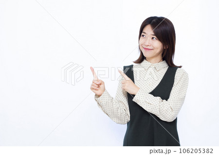 白い背景の前で指差しをしている30代の女性 白い背景の前で指差しをしている30代の女性 106205382