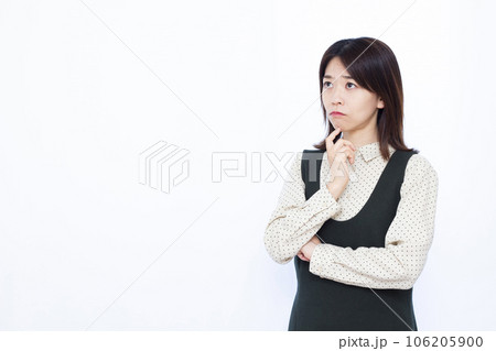 白い背景の前で悩んでいる30代の女性 106205900