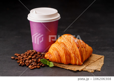 Aromatic coffee in a paper cup paired with a flaky croissant 106206308