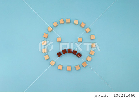 ウッドキューブを並べて作った困っている表情の丸いアイコンの正面 106211460