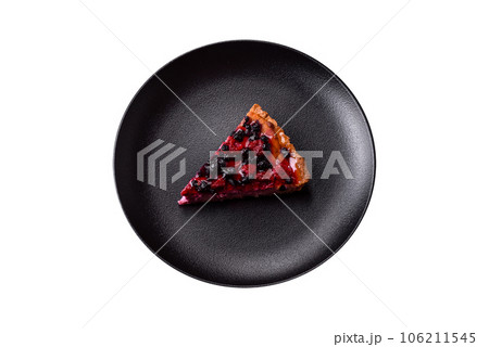 Delicious fresh pie with raspberries and other berries and cheese on a dark plate 106211545