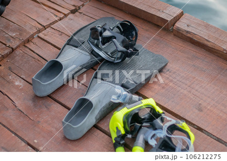 Full set of Scuba Diving equipment with selective focus on wooden pier. Fins, Depth Gauge, Balanced Regulator,Power Inflator, Dive Mask and Snorkel. Scuba gear and accessories. Full set of Scuba Diving equipment with selective focus on wooden pier. Fins, Depth Gauge, Balanced Regulator,Power Inflator, Dive Mask and Snorkel. Scuba gear and accessories. 106212275