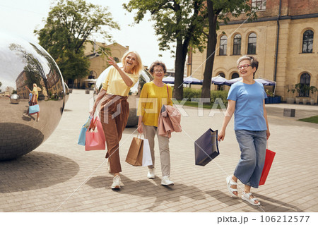 Joyful old women friends after shopping having fun while walking outdoors Joyful old women friends after shopping having fun while walking outdoors 106212577