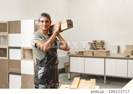 Portrait of young male carpenter standing in the wood workshop 106212717