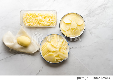 Potato, shredded potato, and potato chips placed on a marble slab. Potato, shredded potato, and potato chips placed on a marble slab. 106212983