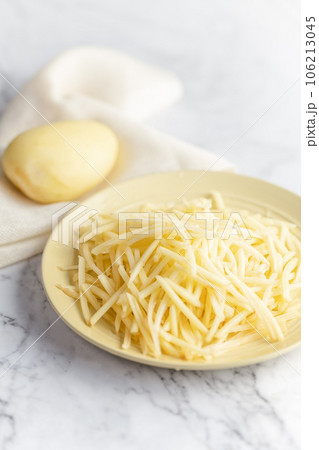 Potato and shredded potato placed on a marble slab. Potato and shredded potato placed on a marble slab. 106213045