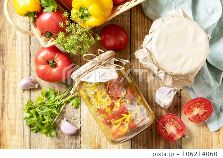 Healthy homemade fermented food. Salad tomatoes with vegetables on a rustic table. Home economics, autumn harvest preservation. View from above. Healthy homemade fermented food. Salad tomatoes with vegetables on a rustic table. Home economics, autumn harvest preservation. View from above. 106214060