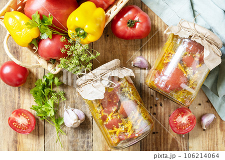 Healthy homemade fermented food. Salad tomatoes with vegetables on a rustic table. Home economics, autumn harvest preservation. View from above. Healthy homemade fermented food. Salad tomatoes with vegetables on a rustic table. Home economics, autumn harvest preservation. View from above. 106214064