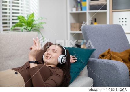 The girl is lying on the couch and one hand is held under her head The girl is lying on the couch and one hand is held under her head 106214068