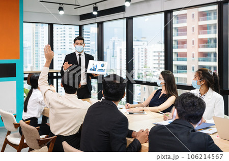 Multiethnic business meeting with businessman presentation of business plan with laptop and colleague raising hand in modern office 106214567