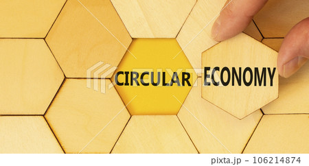 Circular economy symbol. Concept words Circular economy on beautiful wooden puzzles. Beautiful yellow background. Businessman hand. Business circular economy concept. Copy space. 106214874