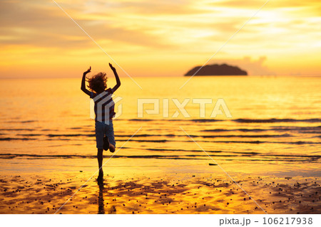 Child playing on ocean beach. Kid at sunset sea. 106217938