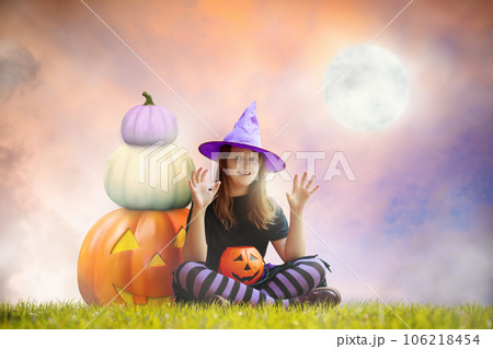 Child and on giant pumpkin lantern on Halloween 106218454