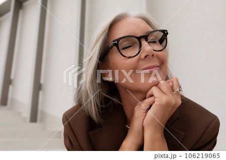 60 year old well-groomed slender gray-haired business woman dressed stylishly enjoys freedom during 60 year old well-groomed slender gray-haired business woman dressed stylishly enjoys freedom during 106219065