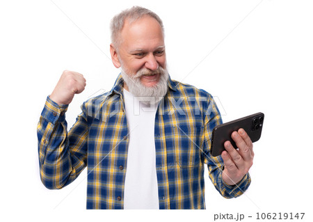 smiling kind 50s mid aged gray-haired man with beard watching video on smartphone on white 106219147