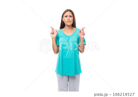 30 year old pretty brunette woman with black flowing hair crossed her fingers and hope for good luck 106219527