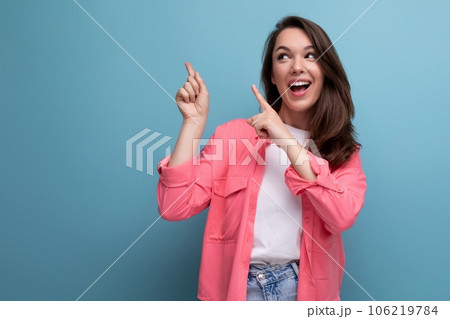 stylish brunette woman in trendy shirt rejoices on studio background 106219784