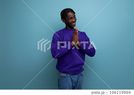 funny dark-skinned american young brunette man with dreadlocks in a blue sweatshirt 106219989