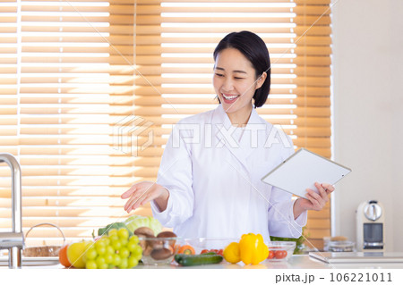 タブレットを見ている栄養士 106221011