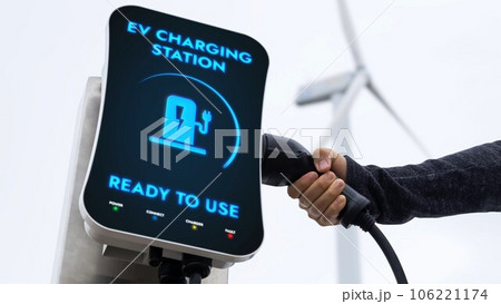 EV charger from EV car charging station at wind turbine. Persuse EV charger from EV car charging station at wind turbine. Persuse 106221174