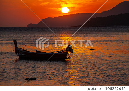 amazing yellow sky of sunrise above the island. The brilliant yellow hue of the sky created a breathtaking scene as the sun slowly rose over the island. fishing boats parking on the golden sea. amazing yellow sky of sunrise above the island. The brilliant yellow hue of the sky created a breathtaking scene as the sun slowly rose over the island. fishing boats parking on the golden sea. 106222033