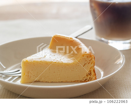白い皿の上のベイクドチーズケーキとアイスコーヒー 106222063