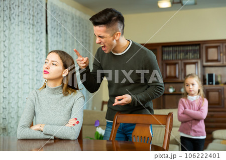 Husband screams at his wife with small child Husband screams at his wife with small child 106222401