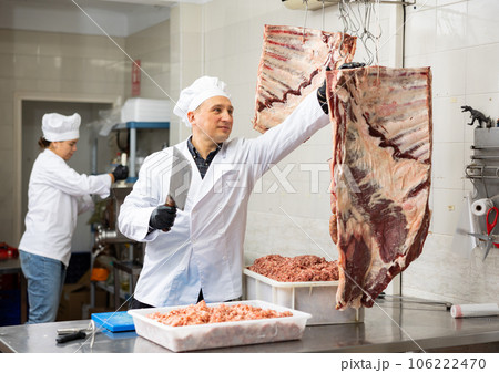 Confident male butcher holding big chunk of beef ribs is prepared in butchery 106222470