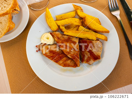 Pork secret served with potatoes on platter 106222671