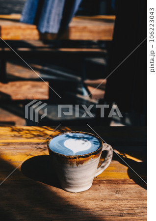 A cup of Blue latte on wooden table. The vibrant blue colour of the drink is natural, Made from micro-milled Butterfly Pea Flower, which originated in Thailand. 106223043