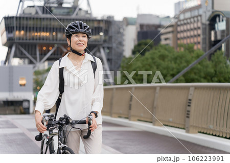 夕方、ヘルメットをかぶってロードバイクで自転車通勤するアラフィフ女性 106223991