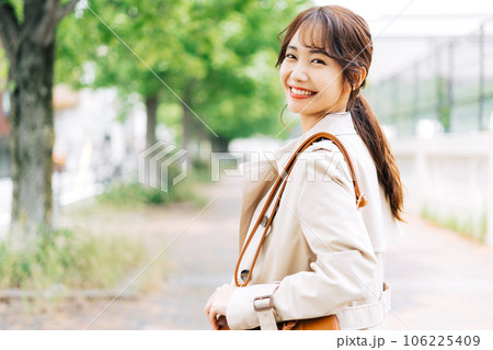 トレンチコートを着て街ブラする女性 106225409