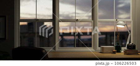 Close-up image of a copy space on a wooden table against the window with a sunset view 106226503