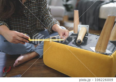 Women use measure tape equipment to measuring size for assembly leg of chair while making furniture Women use measure tape equipment to measuring size for assembly leg of chair while making furniture 106226809