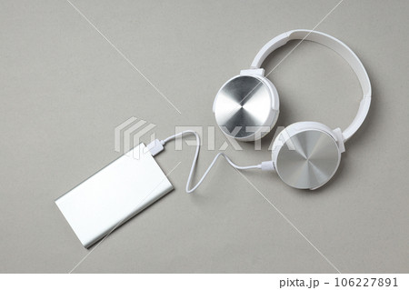 Powerbank and headphones on gray background, top view 106227891